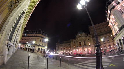 Fototapeta na wymiar Traffic at the street near Opera National de Paris in the nighttime. Grand Opera Paris, France timelapse