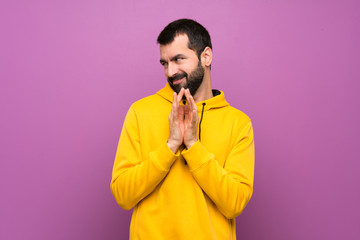 Handsome man with yellow sweatshirt scheming something