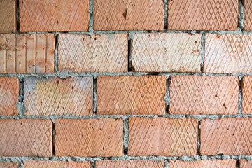 Brick wall of light red color, big bricks, background, texture, pattern with rhombuses