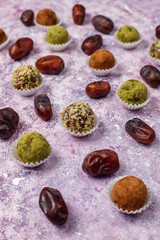 Homemade healthy vegan raw energy truffle balls with dates and walnuts,matcha powder,cocoa powder on light background