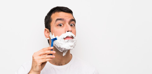 Man shaving his beard over isolated white background