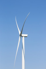 Electricity generating wind turbines with blue sky in background