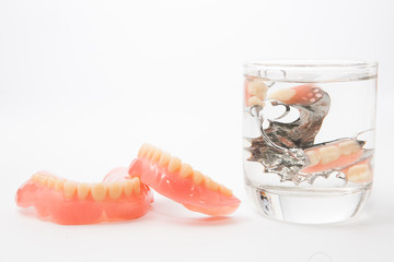 denture is cleaned in a glass of water. proper hygiene.