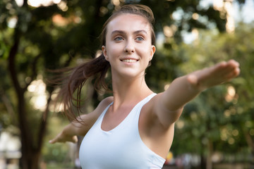 healthy happy strong yoga woman doing Virabhadrasana or warrior pose; concept of woman with healthy...