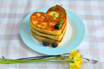 Tasty pancakes with butter and berries on plate.pancakes in the shape of a heart.