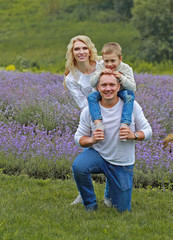  happy family with boy relax in lavender field in summer