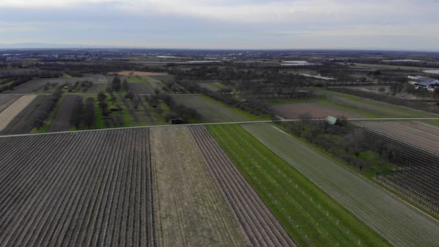 Aerial view of a small town and farmland on a cloudy day. Aerial pan left, Oberkrich, Germany