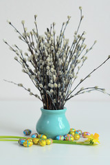 Festive Easter spring composition with pussy willow branches with catkins and multicolored eggs.Easter Background. Springtime. Invitation card design with copy space. Easter card template.