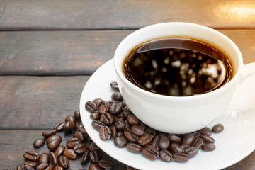 black coffee with shadow bokeh in a classic coffee cup with coffee beans on the wooden table background