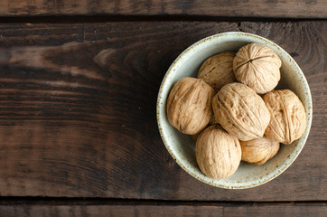 walnut with shell in bowl on wooden background. Top view