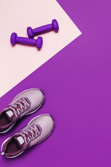 Sports equipment and shoes for women's training. Pink-purple background, diagonal composition.