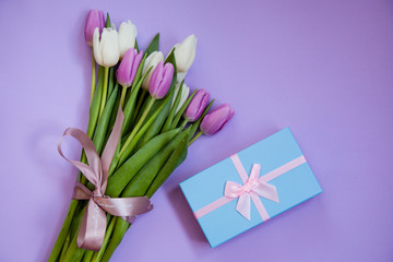 Bouquet of tulips with gift box on a purple background