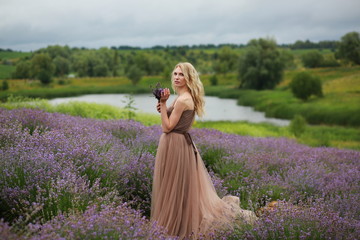  blonde girl in lavender field in summer enjoying vacation