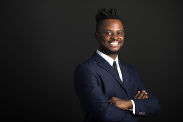 handsome young african man in suit on black background - Powered by Adobe