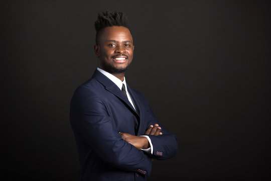 handsome young african man in suit on black background