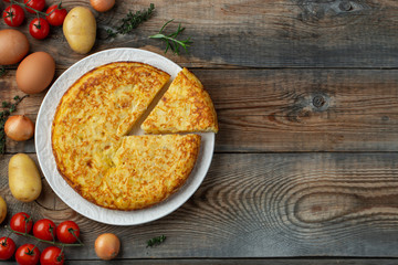 Spanish omelette with potatoes and onion, typical Spanish cuisine. Tortilla espanola. Rustic dark...