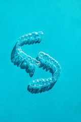 Invisible aligners teeth brackets on blue background
