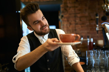 handsome stylish waiter advising wonderful tea for client. close up side view photo. sale, discount , business