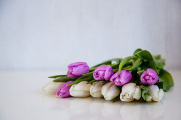 Flowers tulips on a white table.