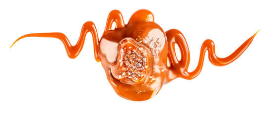 Salty Caramel candies with caramel sauce isolated on a white background close up.