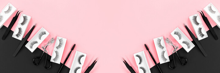 Various tools for eye lash extensions on a trendy pastel pink and black background. Banner....