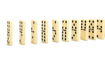Domino's effect composition of a multiple domino bones placed in a row in white background.