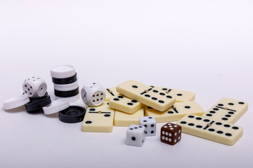Various board games chess, dice and dominoes on a white background.