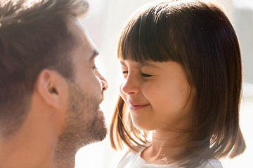 Close up of dad make surprise playing with little daughter