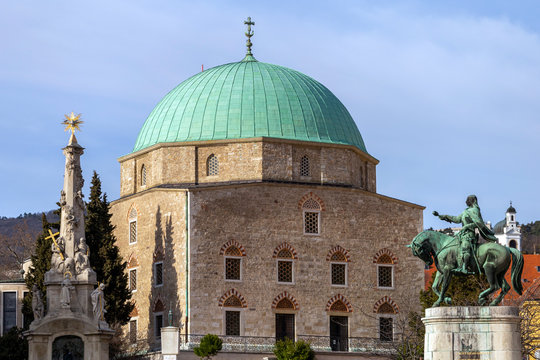 Statue of the Holy Trinity and Hunyadi with the mosque of pasha Qasim the Victorious in Pecs