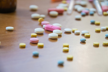 Drugs i and tablets, a spoon and a syringe on a wooden table