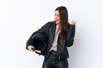 Young brunette woman with a motorcycle helmet over isolated white background celebrating a victory
