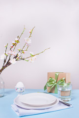 Beautiful table setting for Easter day decorated cherry blossom branch.