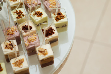 Delicious candy bar at luxury wedding reception. Exclusive expensive catering. Table with modern desserts, cupcakes, sweets. Space for text. Holiday celebration