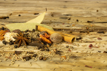 Ingredients of hot spices called garam masala in india on a wooden background