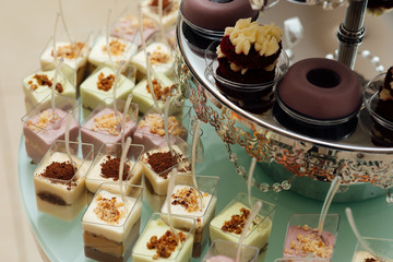 Colorful table with sweets and goodies for the wedding party reception, decorated dessert table. Delicious sweets on candy buffet. Dessert table for a party. cakes, cupcakes. 