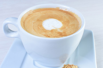 Latte coffee with coffee beans on white wooden background