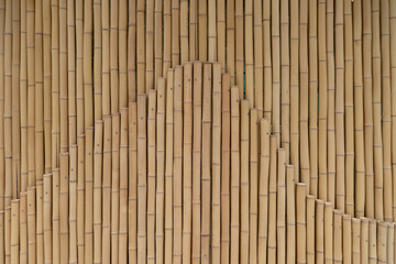 Yellow bamboo sticks in two rows. A fence or fence made of wood. Designer texture for background, place for text copy space