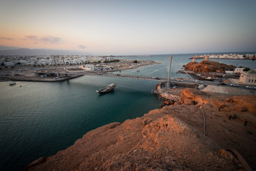 Boat crossing the suspension bridge during at Sur's bay, Oman