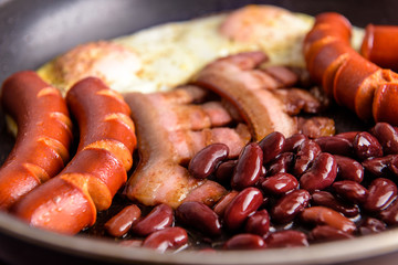 Bacon eggs and sausages in a pan. Full english breakfast