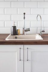 Sink with faucet in the kitchen. leanliness, water saving, washing dishes in a bright Scandinavian interior
