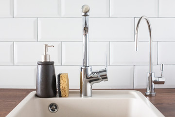 Sink with faucet in the kitchen. leanliness, water saving, washing dishes in a bright Scandinavian interior