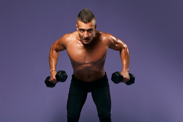 Fototapeta na wymiar serious bodybuilder lifting heavy dumbbells, looking to camera, man working out at gym, keeping fit, close up portrait, isolated blue background, studio shot, weightlifting, effort, motivation