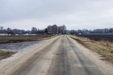 Bad paved road covered with sand sand. Bad asphalt, dangerous road, Broken automobile road, cracks in asphalt