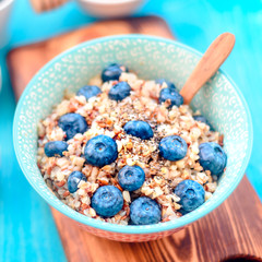 Healthy breakfast ingredients. Buckwheat blueberries mint honey on white wooden background, top view, copy space