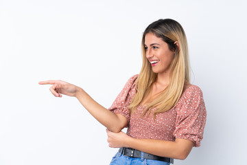 Young Uruguayan woman over isolated white background pointing finger to the side and presenting a product