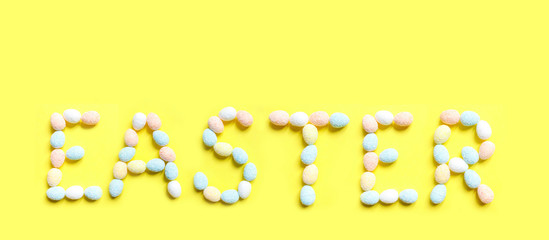 Easter.Text on a yellow background from colorful eggs, handmade banner,holidays background