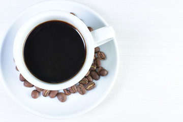 Colombian coffee cup with coffee beans on white wooden background