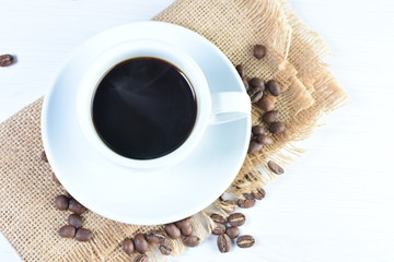 Colombian coffee cup with coffee beans on white wooden background