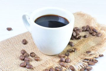Colombian coffee cup with coffee beans on white wooden background