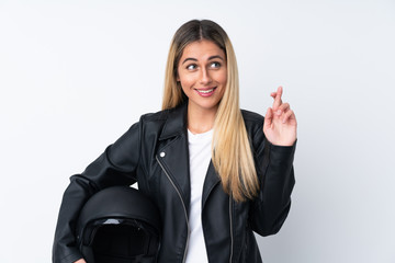 Young Uruguayan woman with a motorcycle helmet over isolated white background with fingers crossing